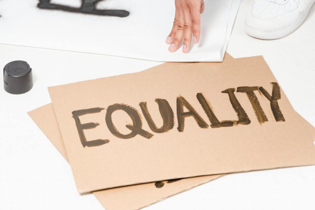 Une pancarte en carton avec inscrit equity représentant le pilier social